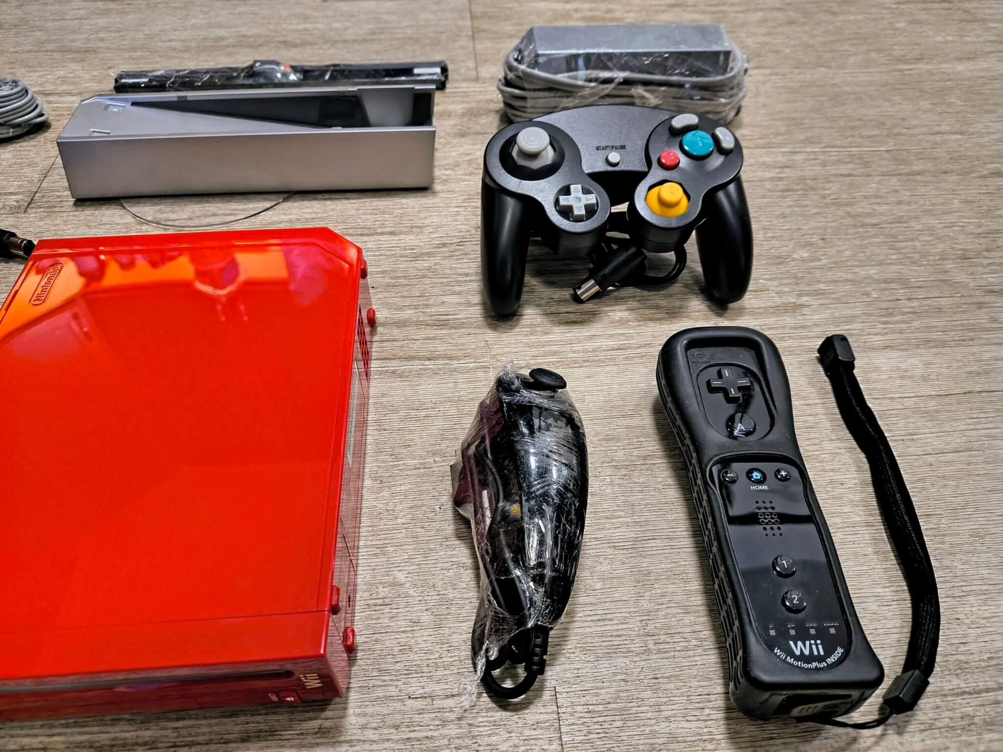 Another Big Bonus! Ships With An Authentic Nintendo Near New Condition Black Motion Plus Remote With Grip, Strap, and NunChuk. We Also Include A New Black After Market GameCube Controller Along With The Base Stand.